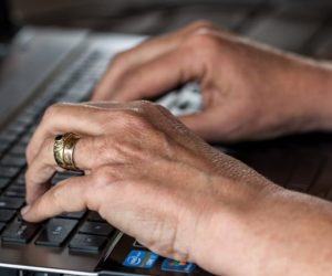 Mains en train de taper sur le clavier d'un ordinateur portable