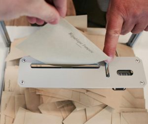 Personne en train de remettre son bulletin de vote dans l'urne